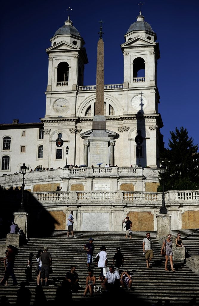 Tourists sit on the Spanish Steps in downtown Rome on August 1, 2010. Photo by Filippo Monteforte/AFP via Getty Images.