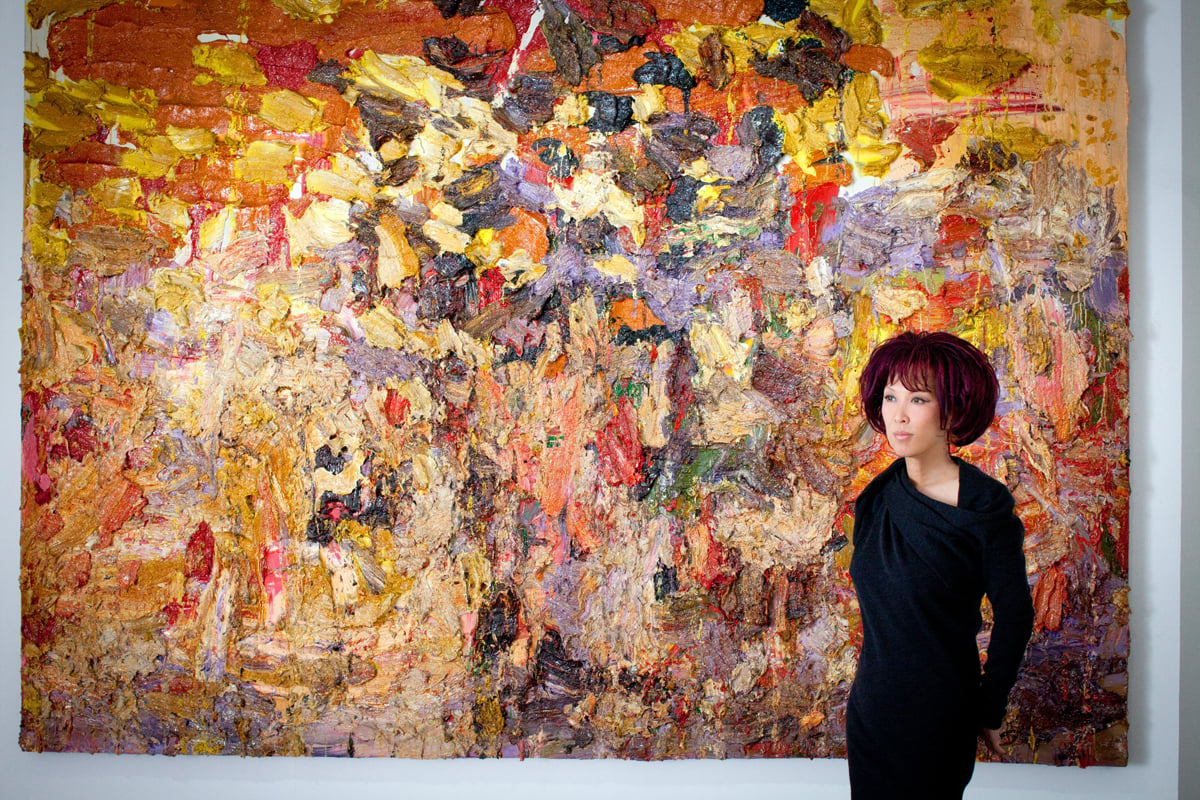Pearl Lam in front of The River Full in Red by artist Zhu Jinshi (The River Full in Red, 2006,  Oil on canvas, 290 x 400 cm) Photo Credit:  Courtesy of Julian de Hauteclocque Howe