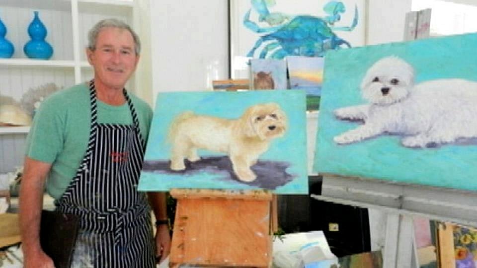 George W. Bush with some of his 50 dog paintings. Video still via Fox Atlanta.