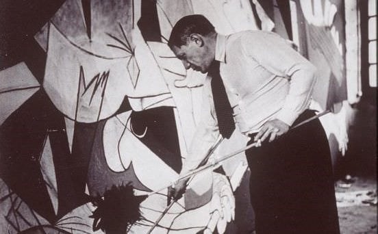 Pablo Picasso working on Guernica (1937).
