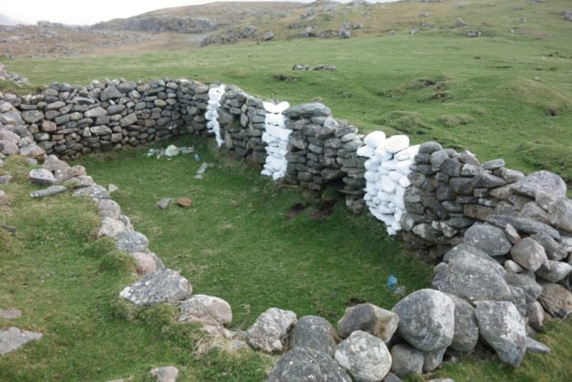 The ruins of the ancient Scottish blackhouse now sports three white stripes. Vandalism, or art?