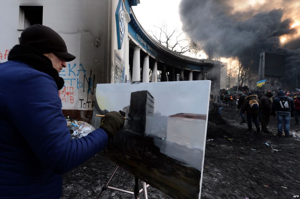 Artist Maksym Vegera painting protesters confronting riot police in Kiev, January 25, 2014. Photo: courtesy Agence France-Presse.