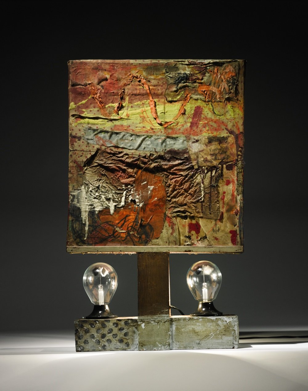 Lot 42 Robert Rauschenberg Combine oil, charcoal, newspaper, canvas and fabric collage, lightbulb and two Crookes radiometers on nailed wooden construction 25¾ x 14½ x 4 in. Est. $5/7 million