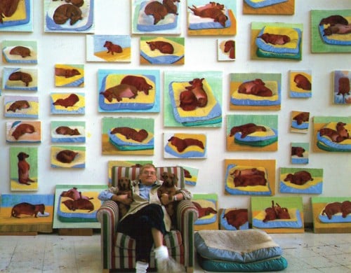David Hockney and his pet dachshunds Stanley and Boodgie photographed in front of some of the artist's many artworks based on the dogs.