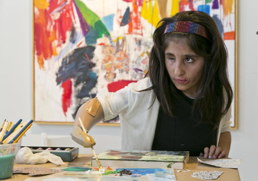 Shah Bibi Tarakhail paints using her prosethetic arm at Galerie Michael, Beverly Hills. Photo: Damian Dovarganes, courtesy the Associated Press.