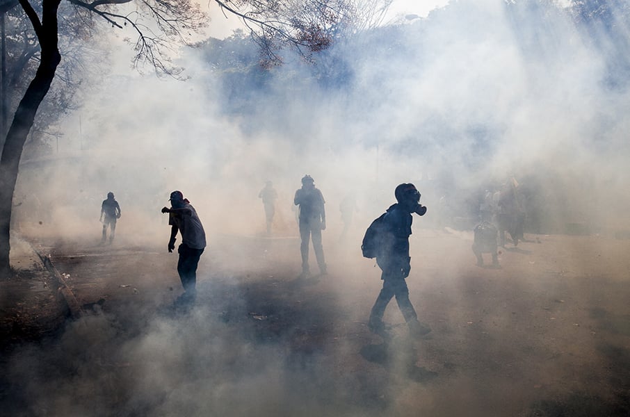 Venezuelan demonstrators walk through a cloud of tear gas released by the police. Photo: Alejandro Cegarra, via NPR's Idea Stream.