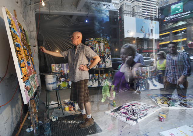 Artist Tom Christopher painting in view of Times Square pedestrians in an active construction site. Photo: Kathy Willens, courtesy AP Photo.