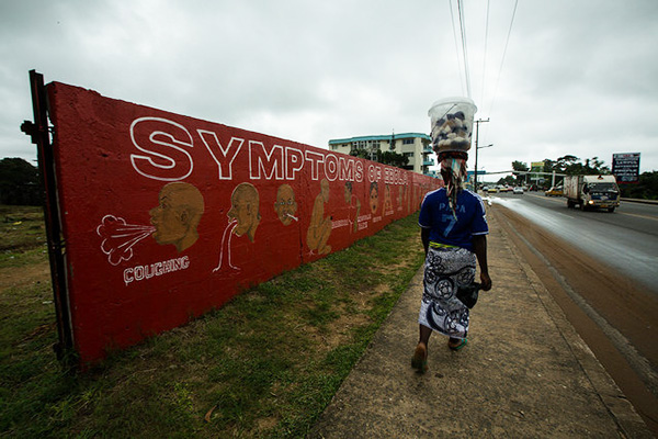 A resident walks past a mural about the dangers of the Ebola Virus painted on a wall off Tubman Boulevard in Monrovia Photo: Morgana Wingard, courtesy United Nations Development Programme