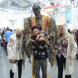 A baby poses with promoters for Zombie Laser Tag at New York Comic Con. Photo: Sarah Cascone.