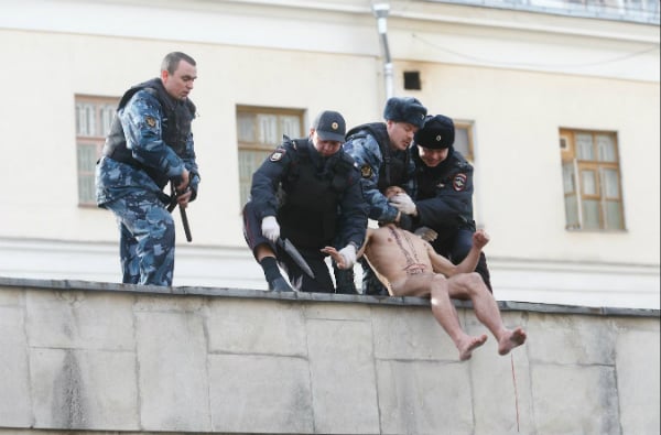  Pyotr Pavlensky is removed by police from the roof of Moscow’s Serbsky psychiatric center, after cutting his earlobe off<br>Photo via: Oksana Shalygina's Facebook