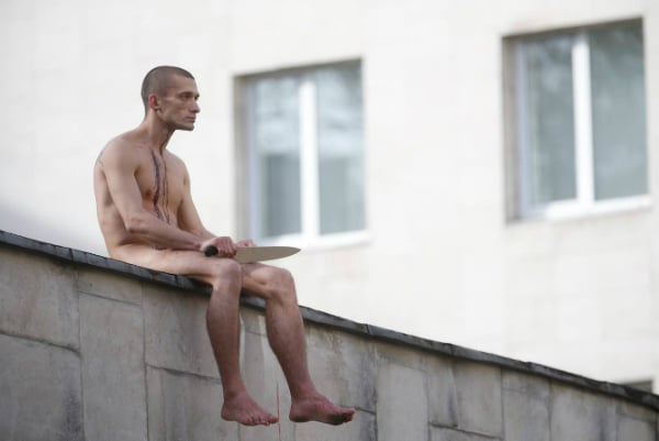 Pyotr Pavlensky after cutting his earlobe off, on the roof of Moscow’s Serbsky psychiatric center. The 2014 performance was called Segregation. Photo by Missoksana, Creative Commons Attribution-Share Alike 4.0 International license.
