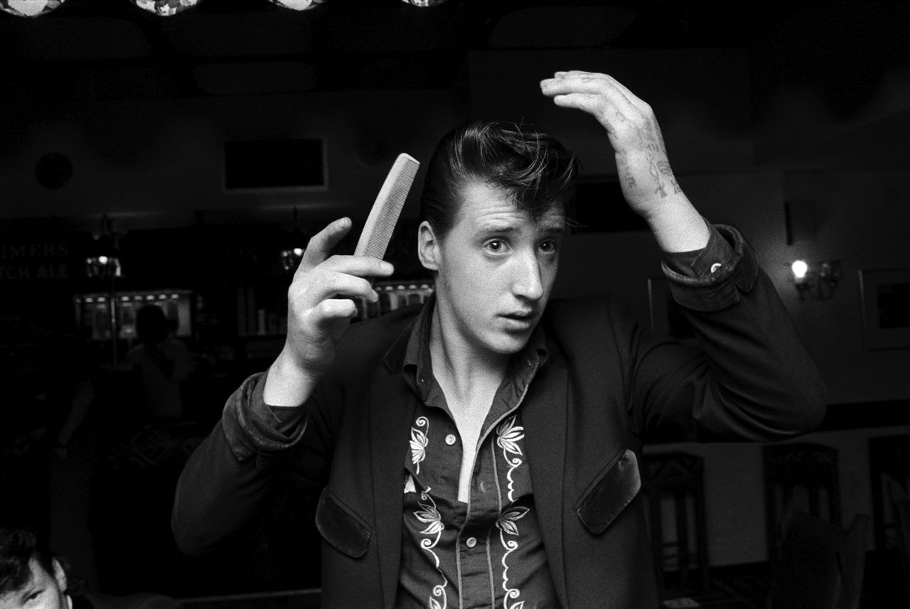 Chris Steele-Perkins, a Teddy Boy combing his hair in the Market Tavern in Bradford, England (1976).<br>Photo: courtesy <em>VICE</em>, Magnum Photos.