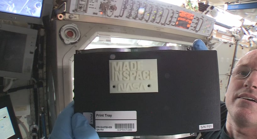 ISS commander Barry “Butch” Wilmore holds up the first 3-D printed part made in space. Photo: Made in Space. 