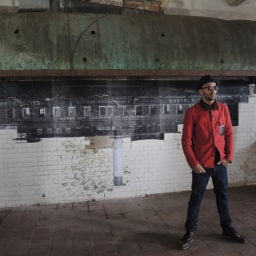 JR in front of part of his installation, "Unframed—Ellis Island." Photo: Sarah Cascone.
