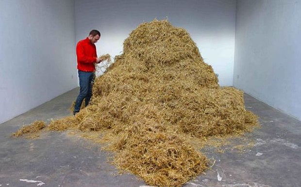 Sven Sachsalber hunts for a needle in a haystack in a performance art piece. Photo: Palais de Tokyo, Paris.