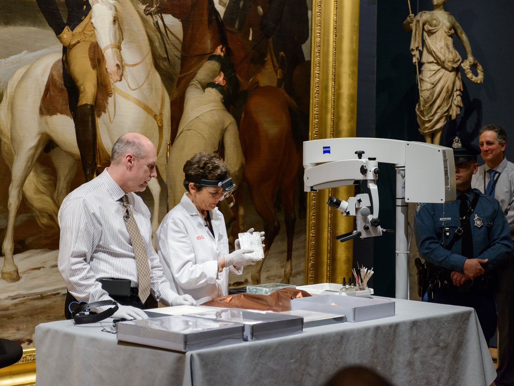 Pamela Hatchfield, Robert P. and Carol T. Henderson Head of Objects Conservation at the Museum of Fine Arts, Boston, and Michael Comeau, executive director, Massachusetts Archives reveal the time capsule's contents. Photo courtesy of the MFA Boston.