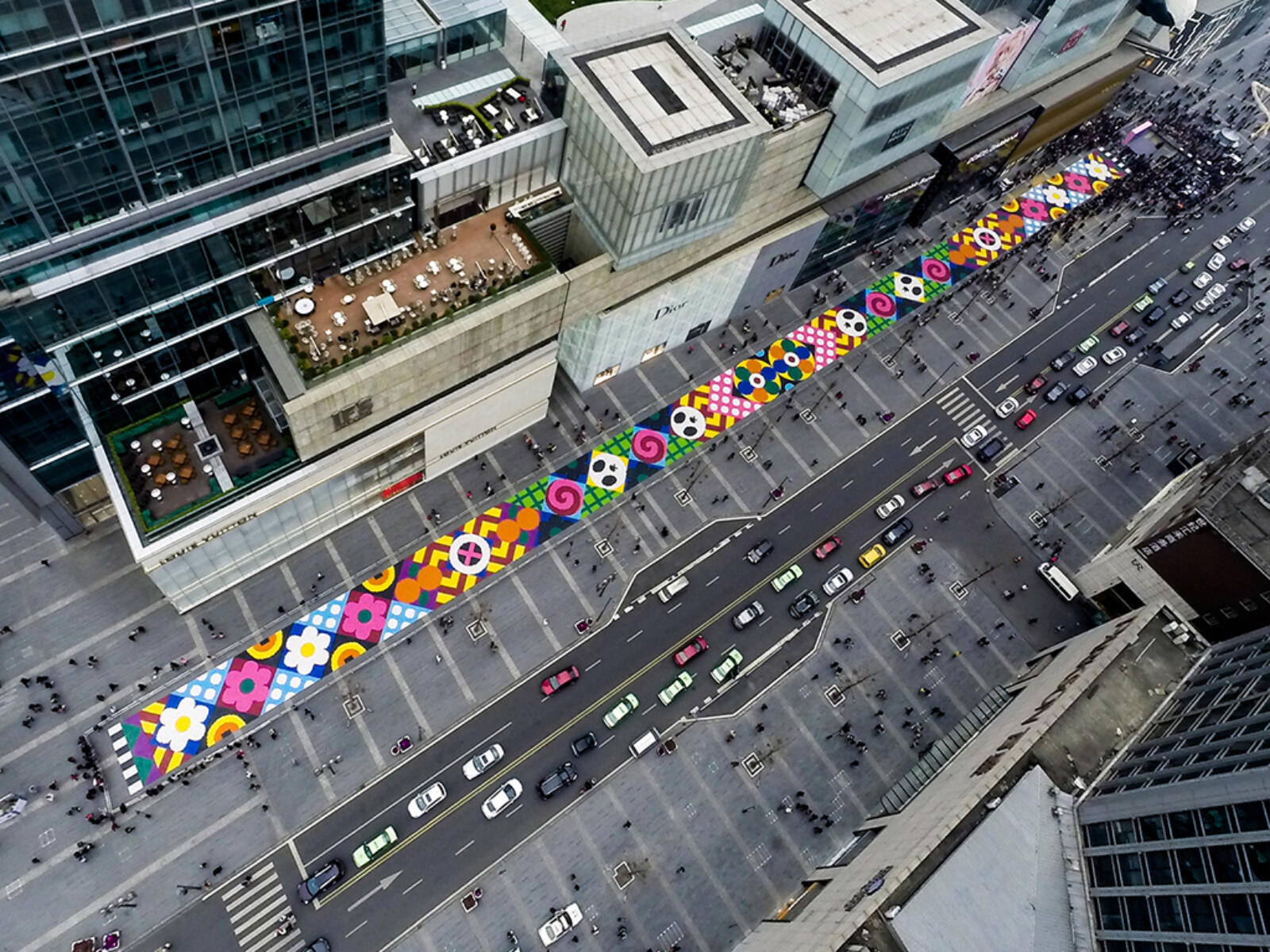 An aerial photograph of a candy mosaic by artist duo Craig and Karl on the street in front of a luxury retail store in Chengdu, China.