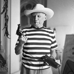 Pablo Picasso handling Gary Cooper’s gun (1958). Photo: André Villers.
