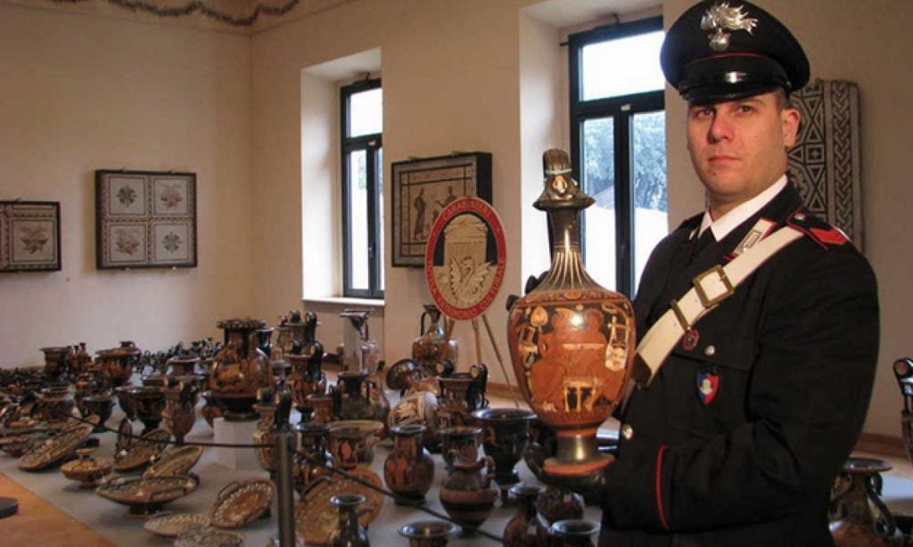 A Carabinieri officer holding one of the recovered antiquities. Photo courtesy of the Ministero dei beni e delle attività culturali e del turismo.