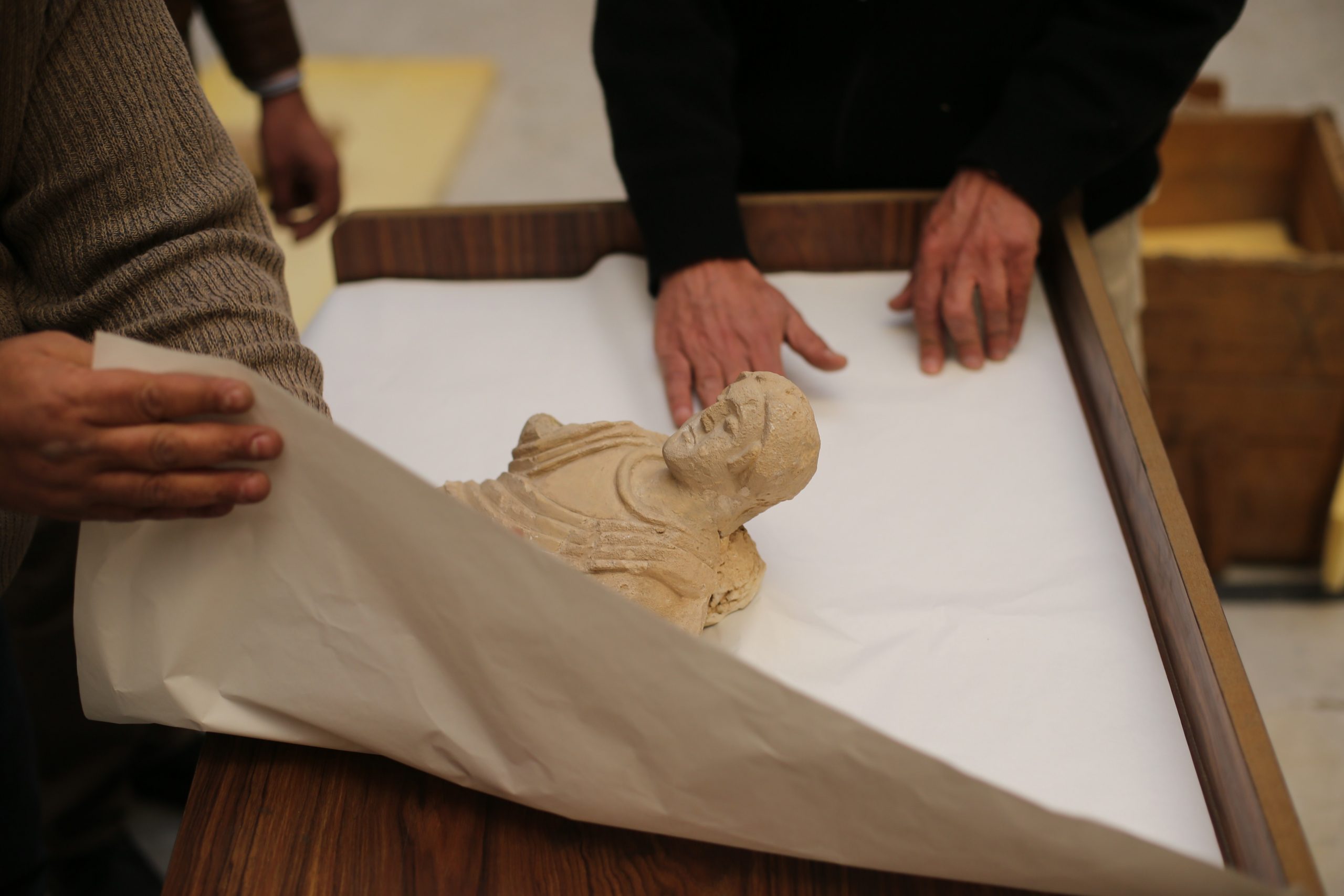 Damascus Museum employees wrap archaeological artifacts into boxes to protect them from being damaged on March 24, 2015, in the Syrian capital. Workers at Syria's National Museum of Damascus carefully wrap statues and place them in boxes to be transported to a safe place, hoping to save the priceless pieces from theft or destruction. Photo by Joseph Eid /AFP via Getty Images.