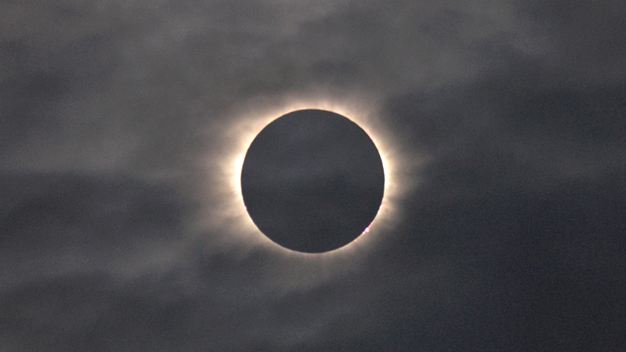 A total solar eclipse is visible through the clouds as seen from Vagar on the Faeroe Islands, Friday, March 20, 2015. Photo: Eric Adams, courtesy AP Photo.