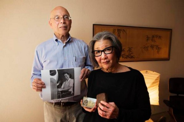 Yoshinori Toso Himel holds an image of his mother working at a photolab in Chicago during World War II that will be auctioned by a New Jersey auction house, Rago Arts and Auctions. His wife Barbara Takei, holds her mom’s cigarette holder made from string and her mom’s military ID. They are fighting to keep the auction house from auctioning off a collection of artifacts, furniture and carvings made by Japanese Americans who spent World War II locked up in incarceration camps. Photo: Paul Kitagaki Jr, courtesy the Sacramento Bee.