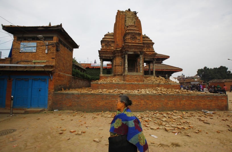 A woman passes a partially collapsed temple in Bhaktapur, near Kathmandu, Nepal, following the devastating earthquake. Photo: Niranjan Shrestha, courtesy AP Photo.