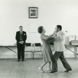 David Goldblatt, Dancing master, Ted van Rensburg, watches two of his ballroom pupils, swinging to a recording of Victor Sylvester and his orchestra, in the MOTHS’ Hall at the old Court House (1979/80)