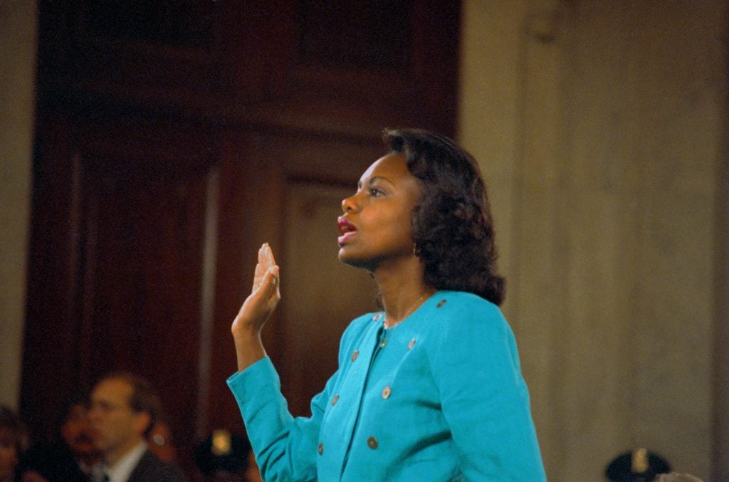 Anita Hill is sworn-in before testifying at the Senate Judiciary hearing on the Clarence Thomas Supreme Court nomination. Hill testified on her charges of alleged sexual harassment by Judge Thomas. Photo from Getty Images.