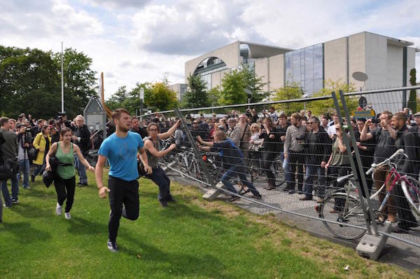 Protestors push over a fence to access the Reichstag Lawn Photo: Vice