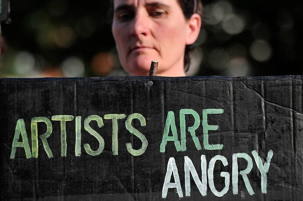 A woman holds a placard outside the Tate Britain after protesters belonging to a group of artists calling themselves 'The Good Crude Britannia', who wants the Tate to cut its ties with British Petroleum (BP). Photo credit Carl Court/AFP/Getty Images.