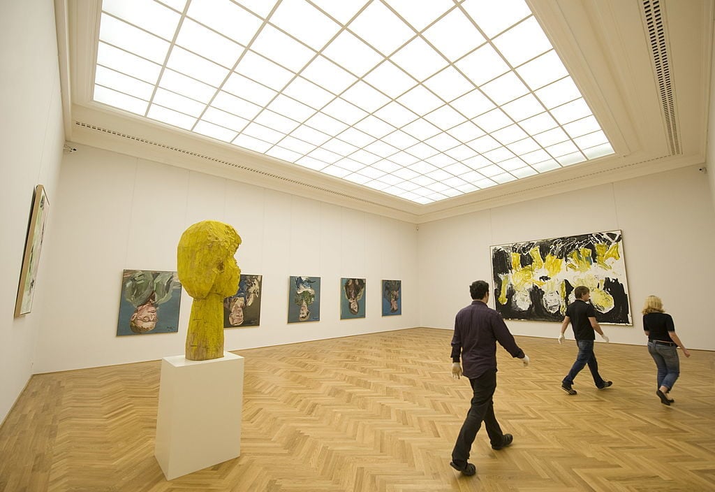  Museum employees walk past works of German artist Georg Baselitz at the Galerie Neue Meister (New Masters Gallery) at the Albertinum museum of the Staatliche Kunstsammlungen Dresden. Photo credit ROBERT MICHAEL/AFP/Getty Images.
