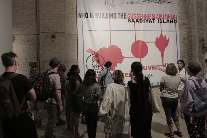 G.U.L.F and Gulf Labor add a Handala stencil to their banner at the Venice Biennale. Photo: Gulf Labor.