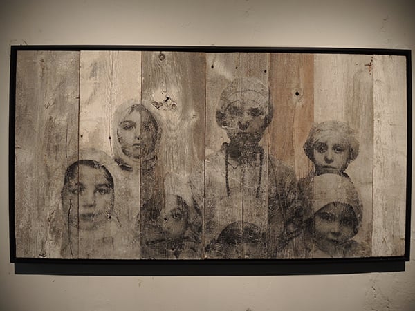 A new JR work on wood based on a piece from "Unframed: Ellis Island," on view in the pop-up exhibition for <em>Ellis</em> on Orchard Street. Photo: Sarah Cascone.