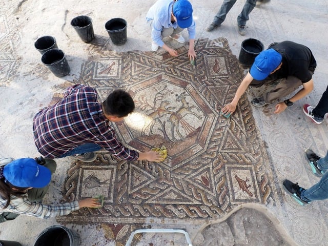 Employee of Israel's Antiquities Authority work on the 1,700-year-old Roman-era mosaic floor discovered in Israel. Photo: Assaf Peretz, courtesy of the Israel Antiquities Authority.