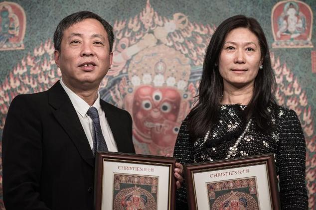 Liu Yiqian and his wife Wang Wei receiving the certificate from Christie's for their purchase of a record-priced Tibetan tapestry. Photo: Phillipe Lopez, courtesy AFP.