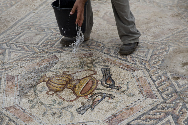 An employee of Israel's Antiquities Authority works on the 1,700-year-old Roman-era mosaic floor discovered in Israel. Photo: AP Photo/Ariel Schalit.