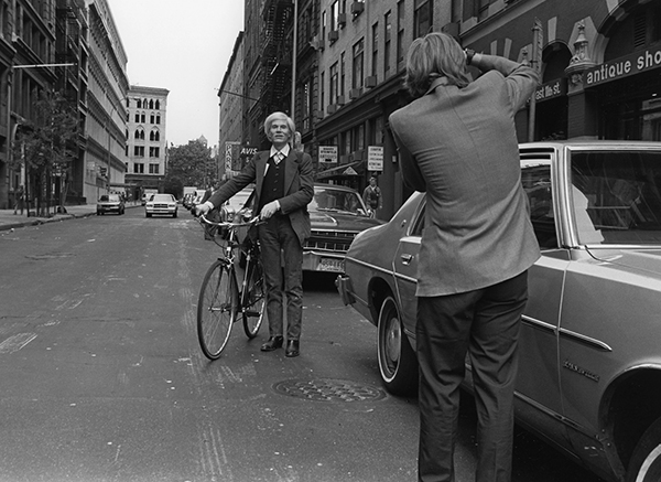 Robert Levin, Andy Warhol with a bicycle on East 11th Street in the Village in New York City (1981). Photo: courtesy Maison Gerard.