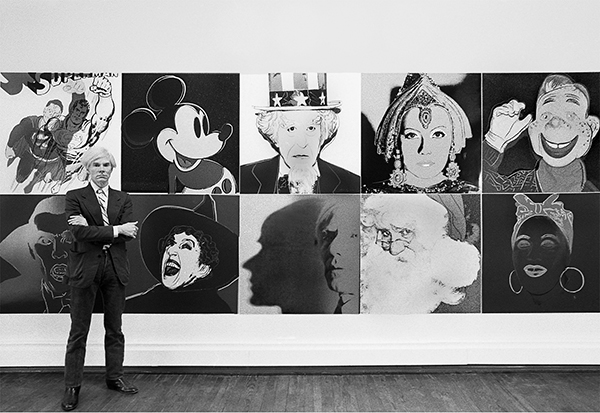 Robert Levin, Andy Warhol standing in front of the installation of the Myths at the Robert Feldman Gallery in New York City (1981). Photo: courtesy Maison Gerard.