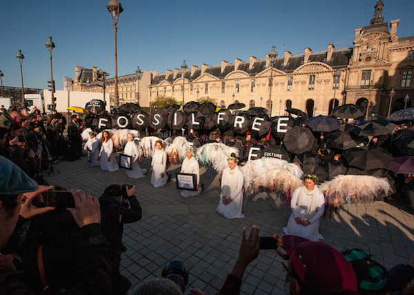 Activists protest in front of the Louvre in Paris during the Paris Climate Summit, calling on the museum to drop sponsors Eni and Total