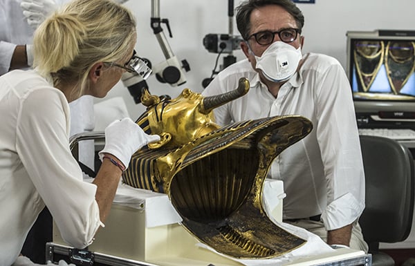 German specialists in Christian Eckmann (R) and Katja Broschat (L), work to restore the golden mask of Tutankhamun after it was damaged in botched repair job. Photo: Khaled Desouki/AFP/Getty Images.