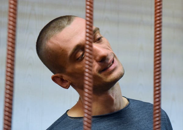 Russian artist Pyotr Pavlensky, accused of vandalism after torching the doors to the headquarters of the FSB security service, stands inside a defendants' cage during a hearing at a court in Moscow on November 10, 2015. Photo: DMITRY SEREBRYAKOV/AFP/Getty Images