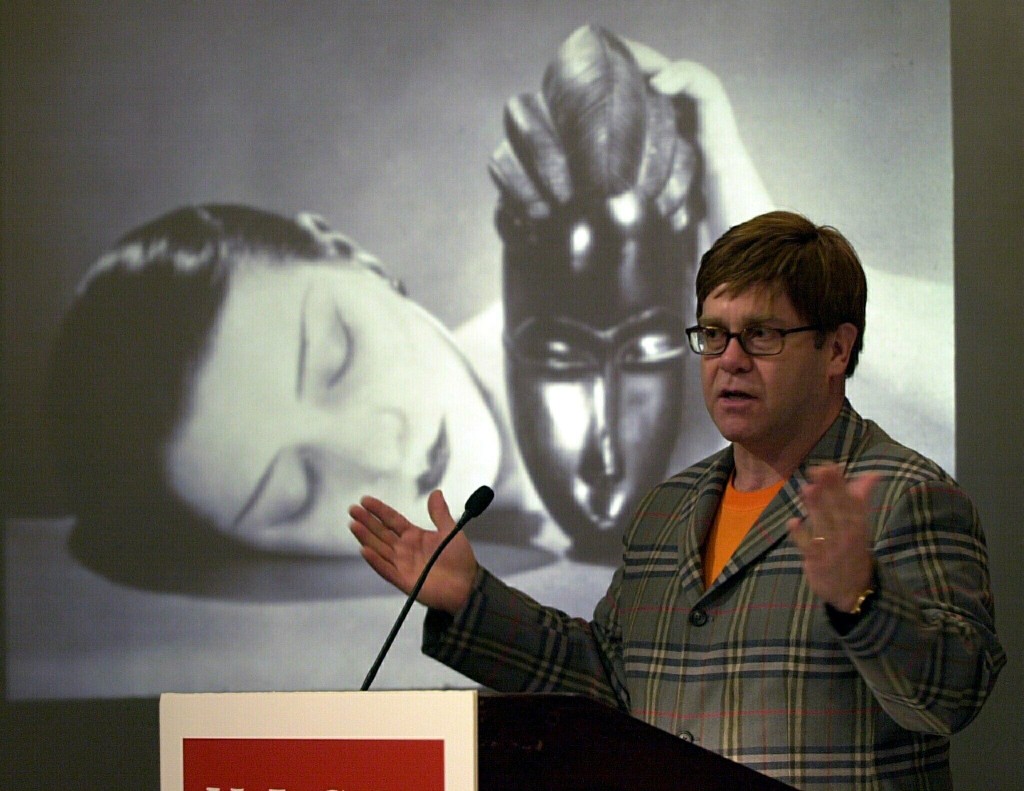 NEW YORK, UNITED STATES: Sir Elton John stands in front of Man Ray's 1926 silver gelatin print, "Noire et Blanche," one of the 380 works from John's the private collection which will be on display at the High Museum of Art in Atlanta, Georgia beginning in November, 2000. John's photos, which were amassed over the past 10 years and number more than 2000, includes works by many of the most famous photographers in the world, including Henri Cartier-Bresson, Alfred Stieglitz, Man Ray, and Edward Weston. AFP PHOTO Henny Ray ABRAMS (Photo credit should read HENNY RAY ABRAMS/AFP/Getty Images)