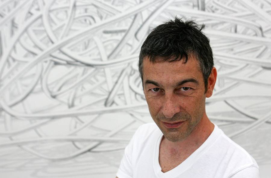 French artist Pierre Huyghe stands in front of one of his pieces, Noeud 01 for Streanside Day on display at the Tate Modern in London, 4 July 2006. "Celebration Park" is Huyghe's first solo exhibition in the UK. Photo: JOHN D MCHUGH/AFP/Getty Images. According to a December press release, this year’s São Paulo Biennial intends to “explore cos