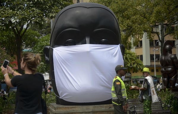A giant mask is seen on the sculpture by Colombian artist Fernando Botero Photo: RAUL ARBOLEDA/AFP/Getty Images