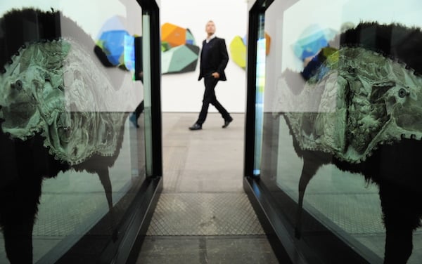 A visitor walks past British artist Damien Hirst's "The Black Sheep with Golden Horns" Photo: JOHN MACDOUGALL/AFP/Getty Images