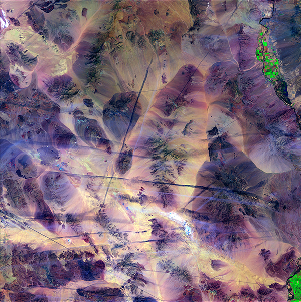 <em>Contrails</em>, "Earth as Art," April 3, 2015. <br>Like scratches on a marble table, airplane contrails cut across the southern California Mojave Desert. The shadows from the contrails cast dark lines across the ground. Contrails form when cold, dry air mixes with warmer aircraft exhaust. Mountains and a few dry lakebeds provide a backdrop to this scene, along with bright green spots of agriculture along the Colorado River. <br>Photo: USGS.
