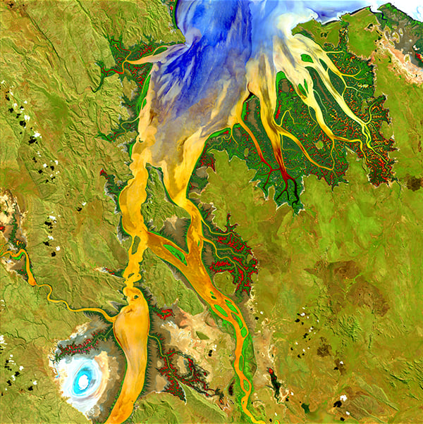 <em>Nature’s Patterns </em>, "Earth as Art," May 12, 2013. <br>The biologically complex conditions of mangroves are shown in dark green along the fingers of the Ord River in Australia. Yellow, orange, and blue represent the impressive flow patterns of sediment and nutrients in this tropical estuary. The bright spot at the lower left is an area of mudflats, which is home to saltwater crocodiles. <br>Photo: USGS.
