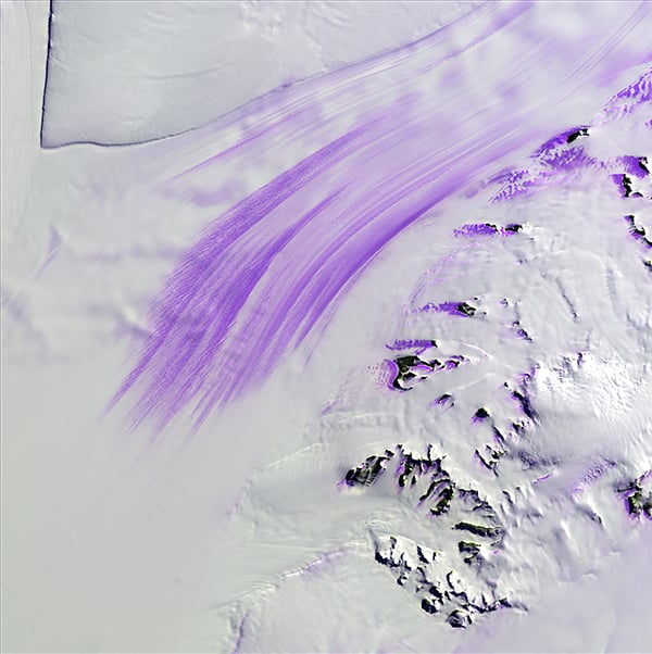 Slessor Glacier, "Earth as Art," November 14, 2014. Slessor Glacier in Antarctica flows between the angular promontory Parry Point on the top left of the image and the Shackleton Range on the lower right. The purple highlights are exposed ice. Strong winds blow away the snow cover and expose lines that indicate the glacier flow direction. Rock outcrops next to the glacier also exhibit some of this bare ice. Photo: USGS.