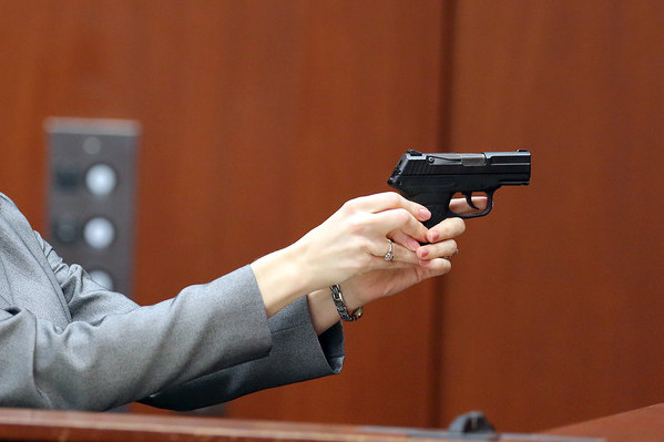Firearms analyst Amy Siewert from Florida Department of Law Enforcement shows the jury how George Zimmerman's gun can be fired. Courtesy of Jacob Langston-Pool/Getty Images.